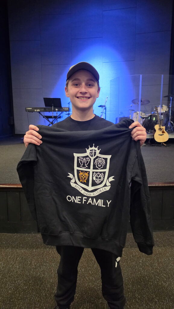 student holding sweatshirt