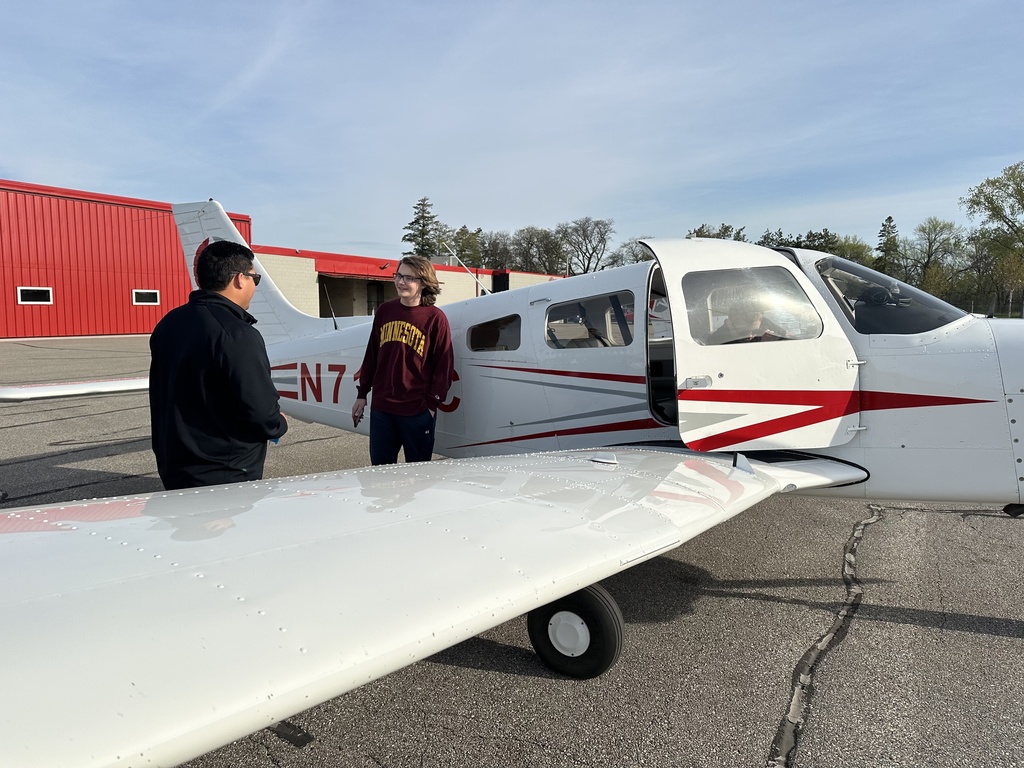 student and instructor by an airplane
