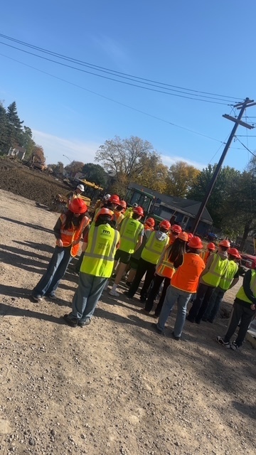 Students listening to road project