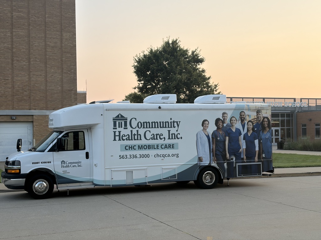 CHC Mobile Bus in front the main entrance to UTHS. Sunrise in background with tree.