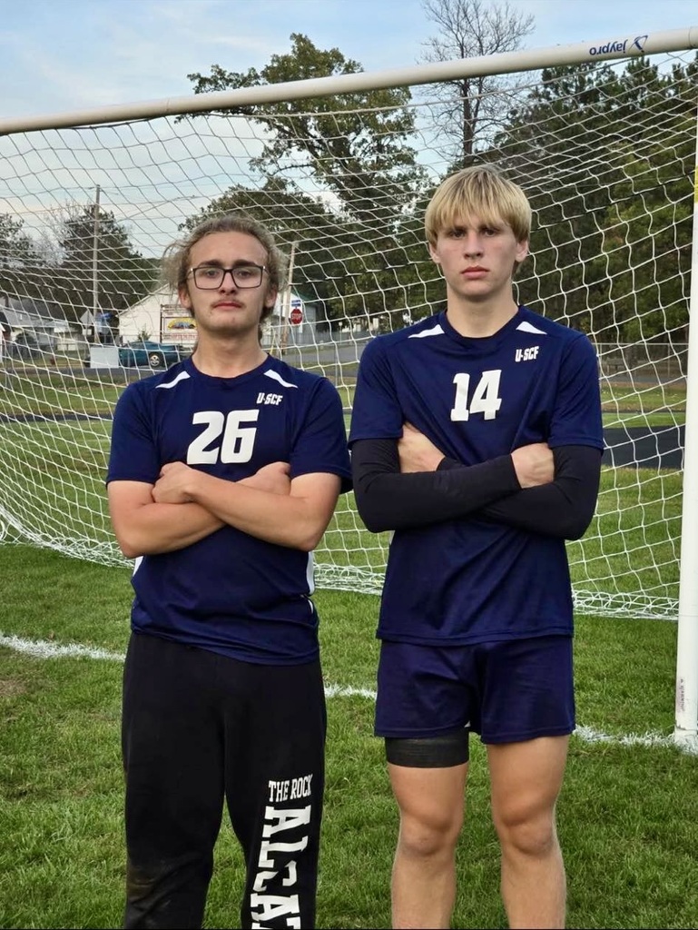 Garrison and Boe posing for a picture in front of the soccer net