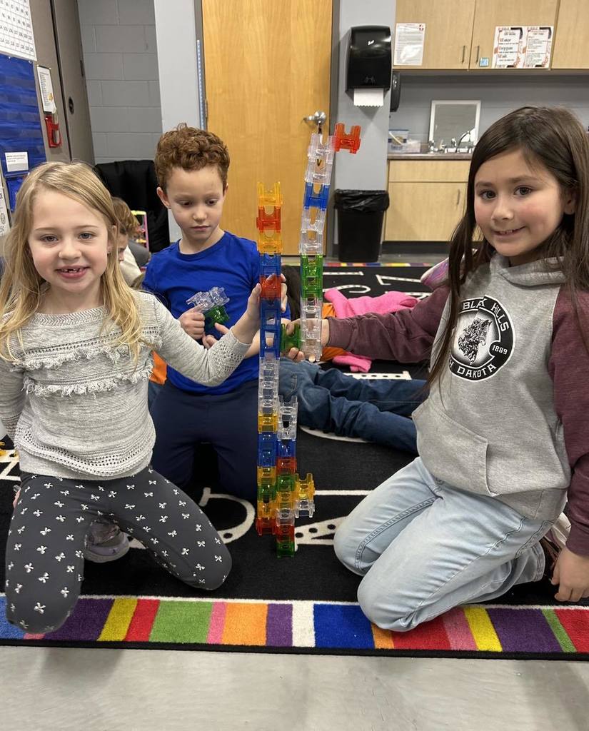 Picture of three children building towers with Magna Tiles during inside recess