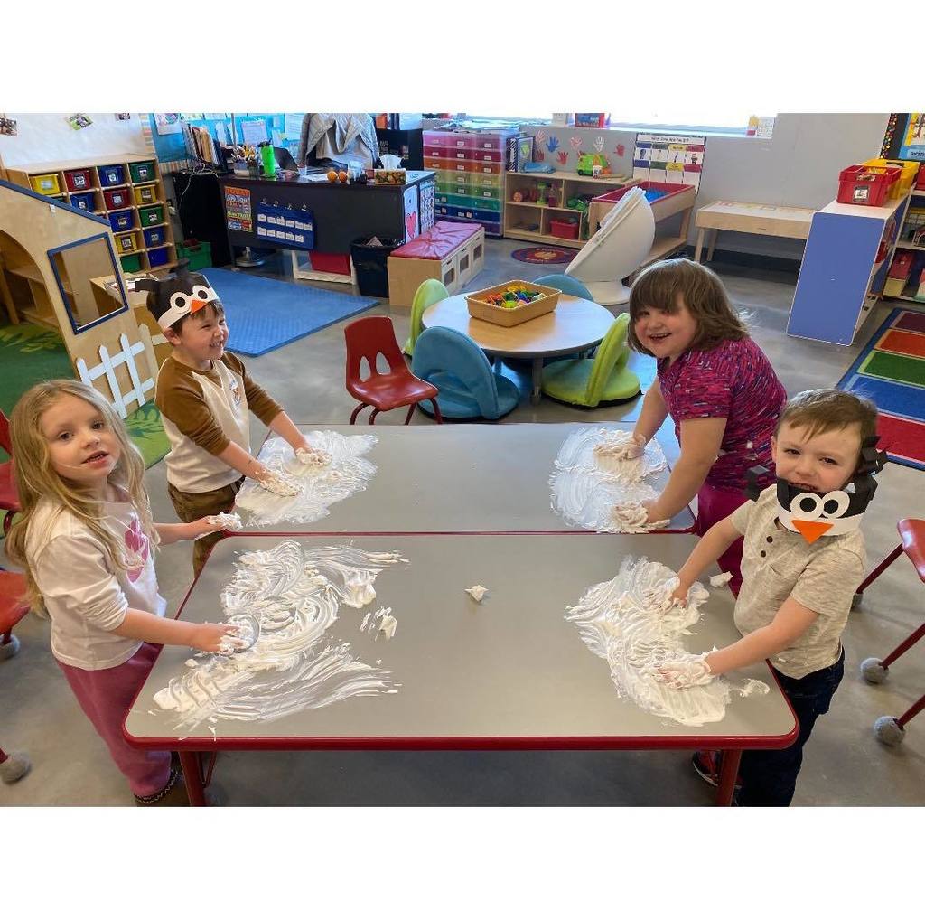 picture of four busy bug students finger painting with shaving cream