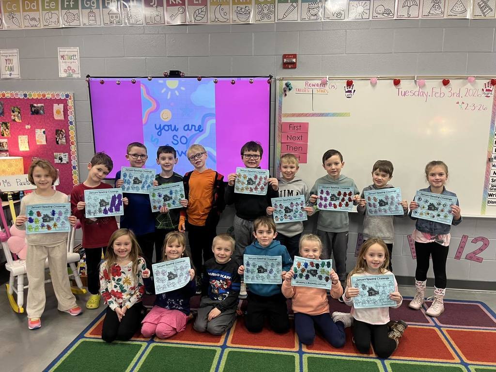 picture of first grade students showing their completed monthly reading calendars