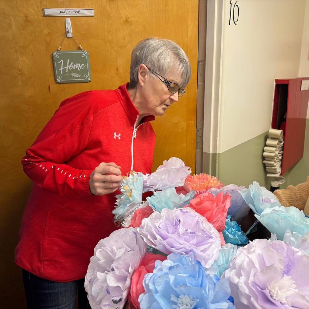 picture of woman looking at paper flowers