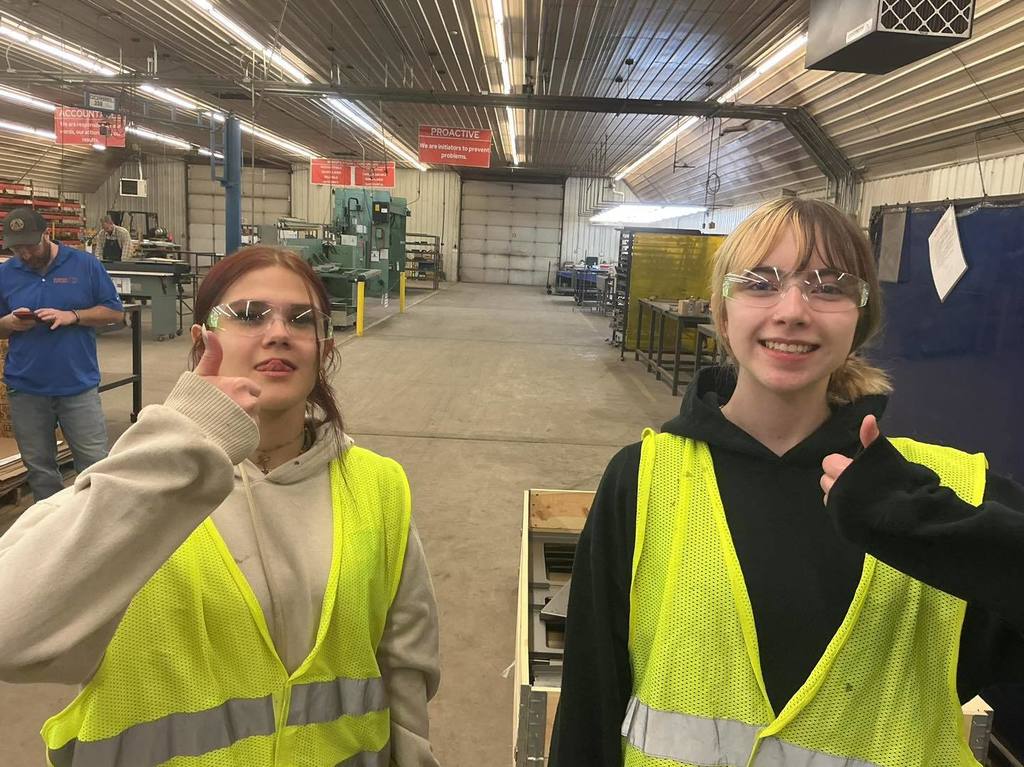 For the photo showing the two students in the foreground, here is your alt-text: