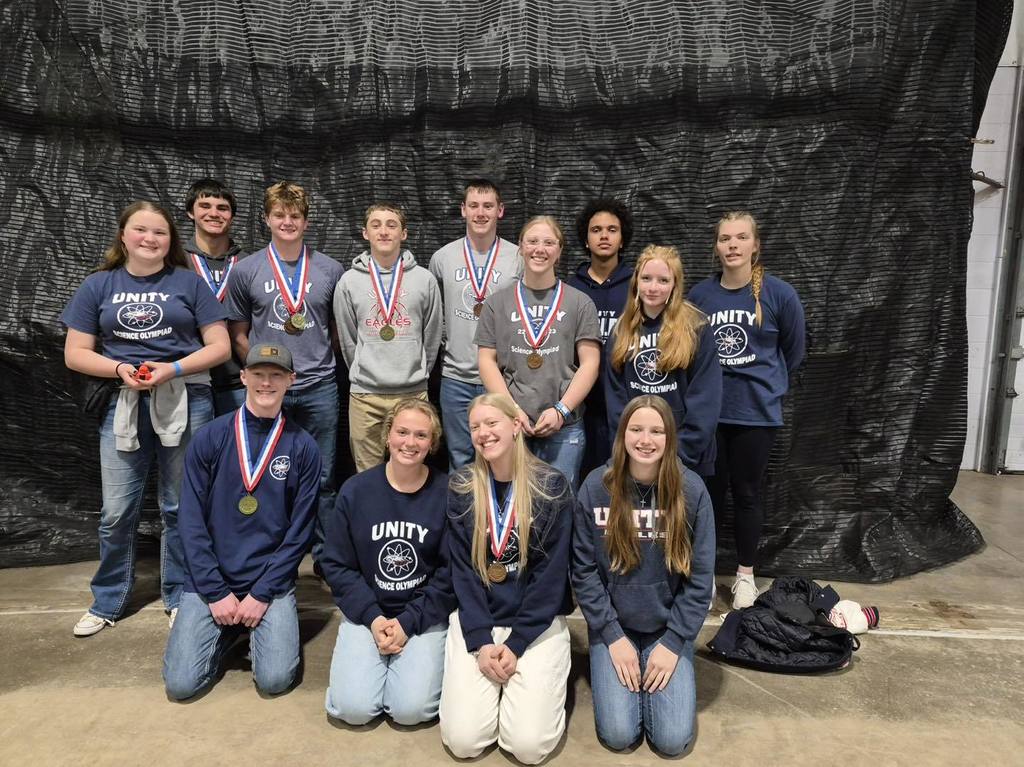 Unity High School Science Olympiad team members posing with their medals in front of a black backdrop at the state competition.