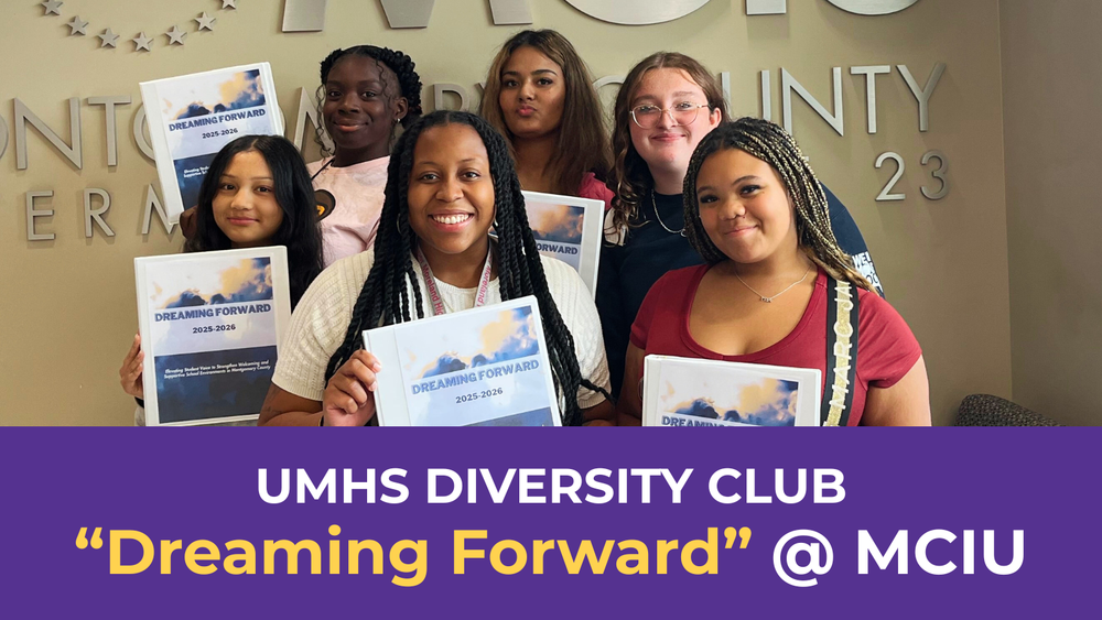 A group of people holding "Dreaming Forward 2025-2026" binders in front of a wall with the text "Montgomery County Intermediate Unit"