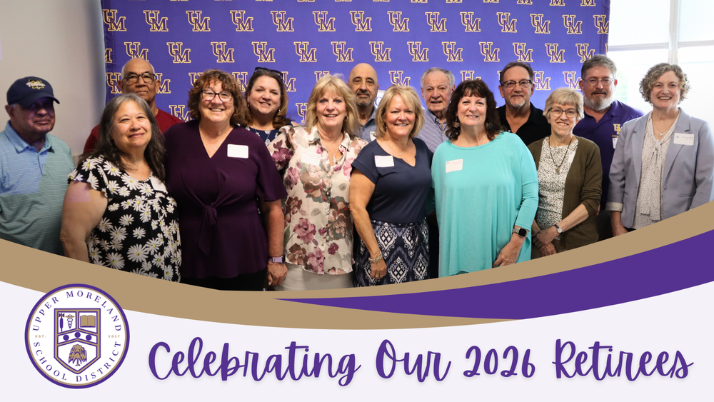 "Group of 14 people smiling in front of a 'UM' backdrop, with a banner reading 'Celebrating Our 2026 Retirees.'"