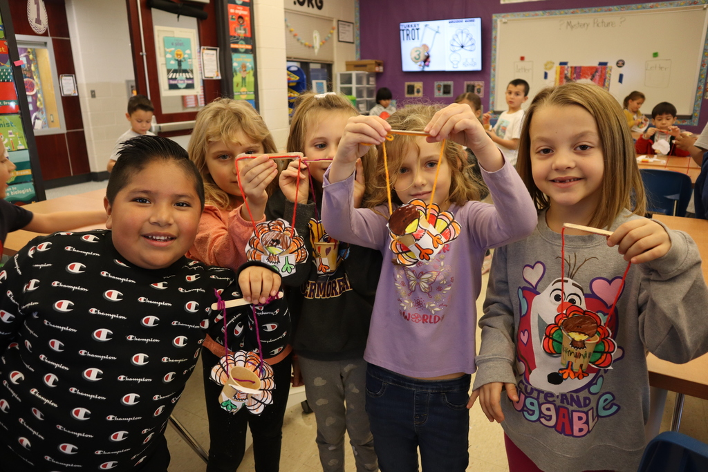 Students holding their turkey marionettes