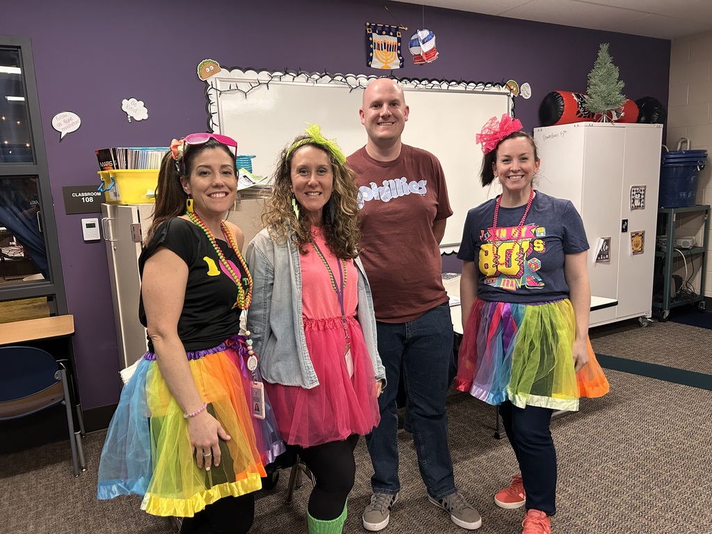 Teachers smiling & dressed in 80s fashion