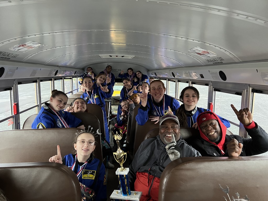 UMMS Winterguard Team group photo in bus with trophy