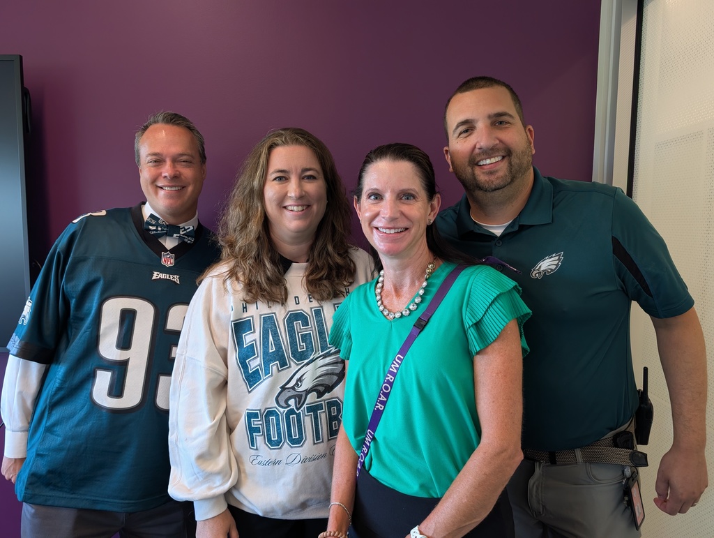 Building principals pose for a photo wearing their Eagles gear