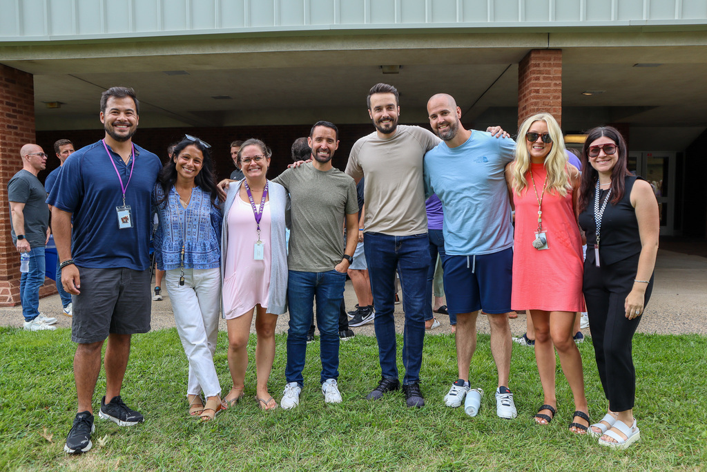 Staff members smile and pose for a photo