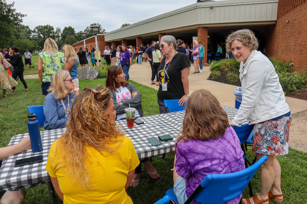 UM Superintendent chats with staff members seated at a table