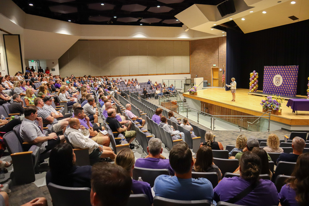 UM Superintendent speaking in front of large group of staff in Middle School auditorium