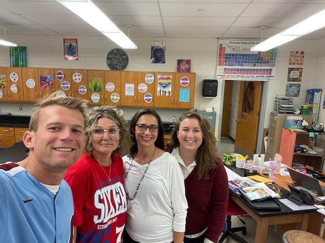 Teachers smile in a group wearing red, white, and blue