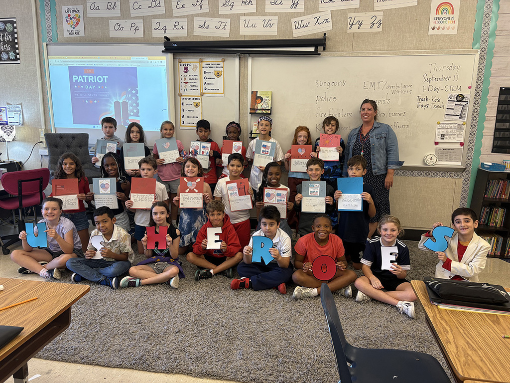 Students smile in a group and hold their Patriotic craft
