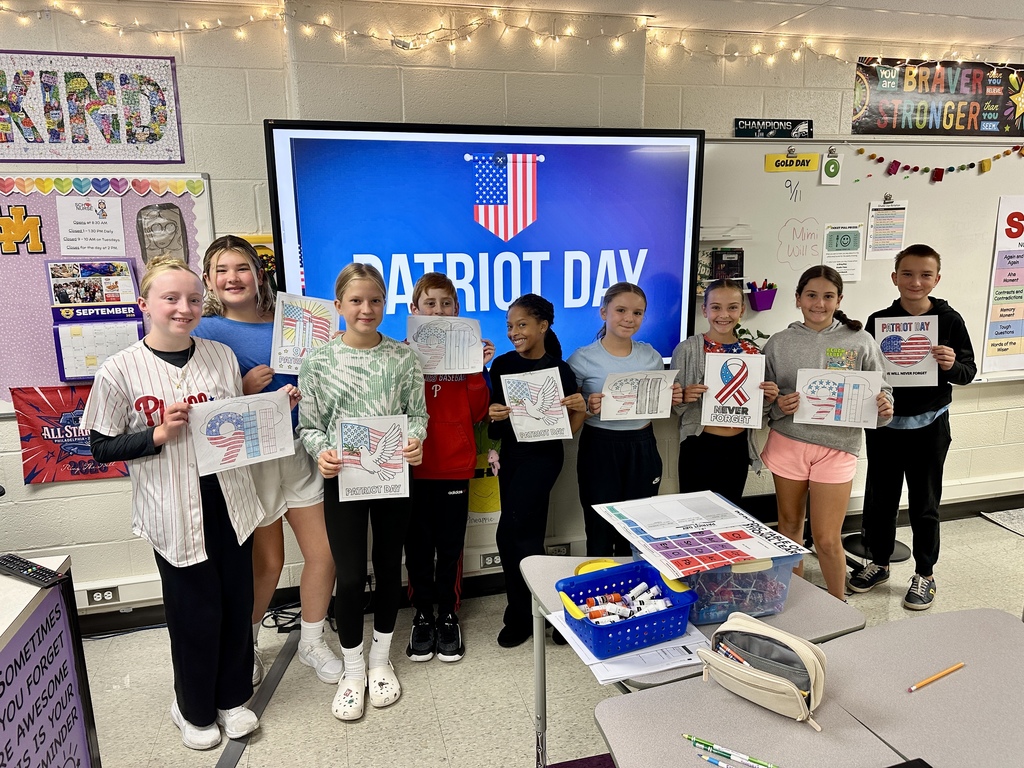 Students smile in a group and hold their Patriotic craft