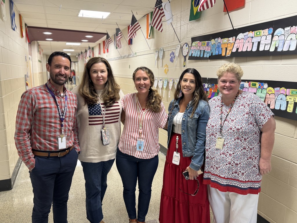 Teachers smile in a group wearing red, white, and blue