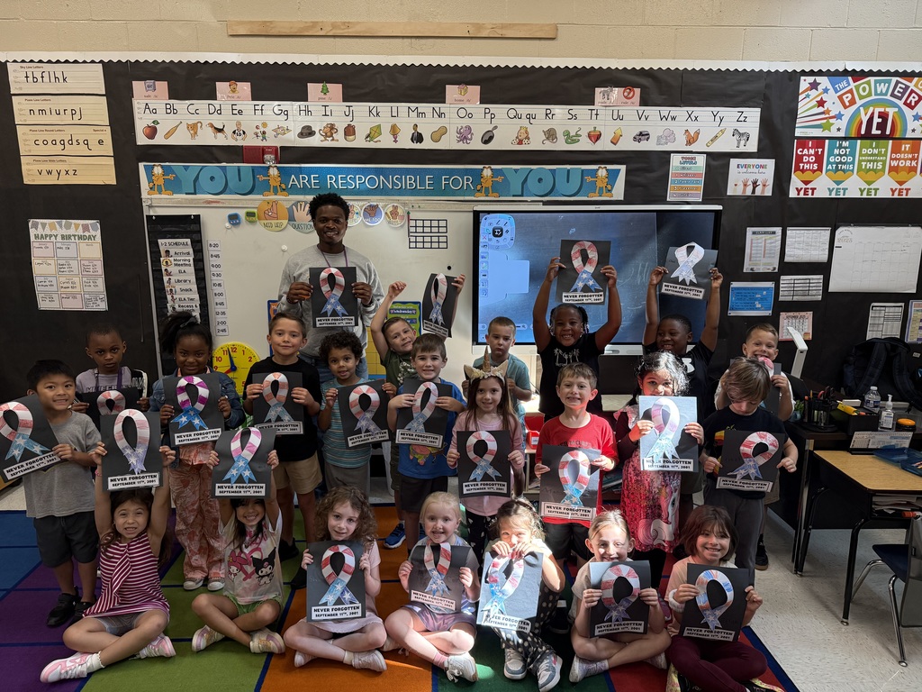 Students smile in a group and hold their Patriotic craft