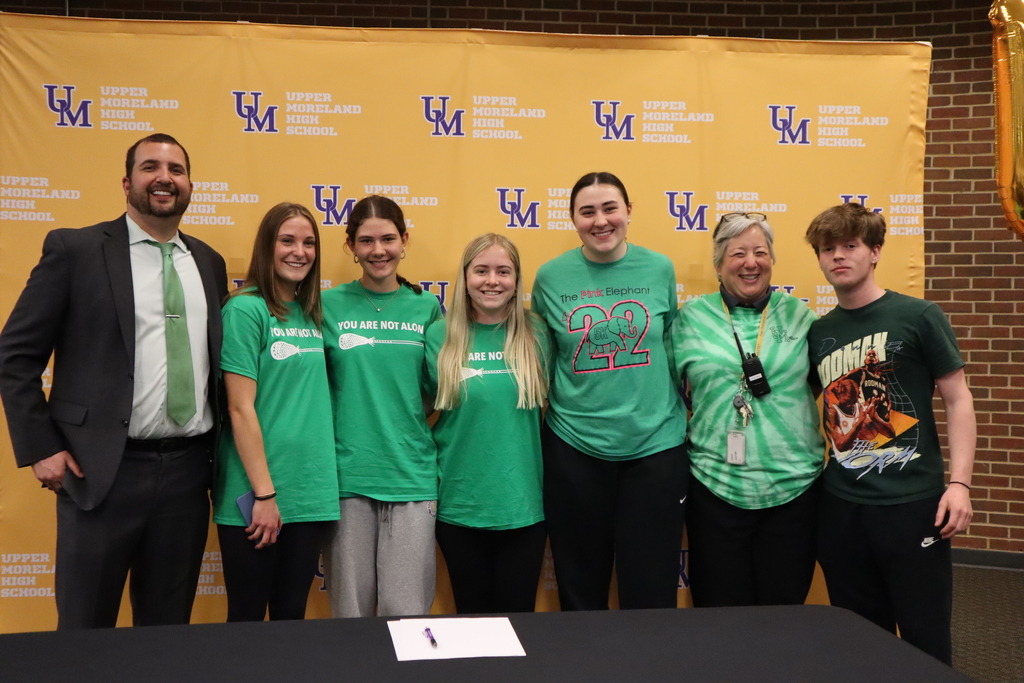 Students and staff pose wearing green