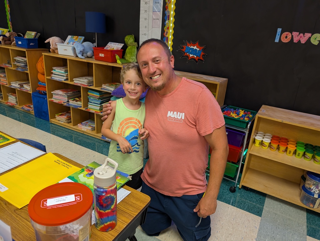 Parent and Kindergartener smiling at his new desk