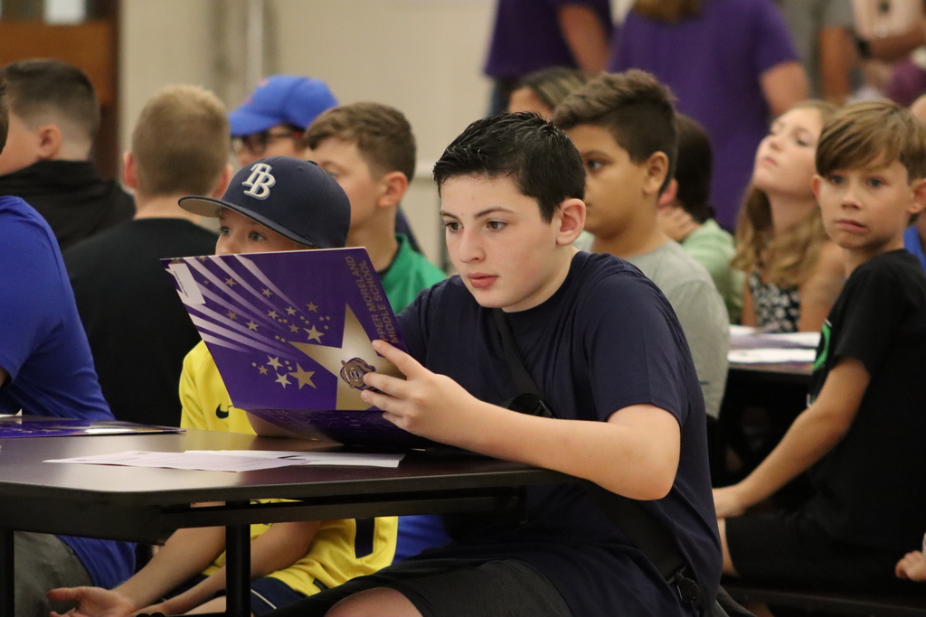 6th grade student sitting at table reviewing his schedule