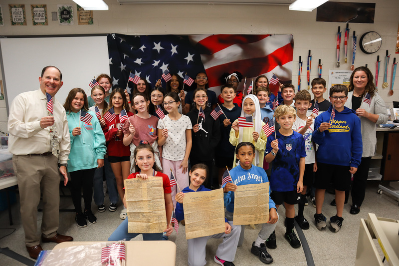 Sixth Graders pose holding American flags