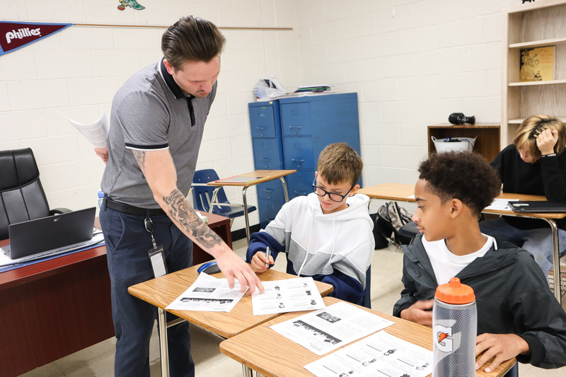 Teacher helps students with their assignment