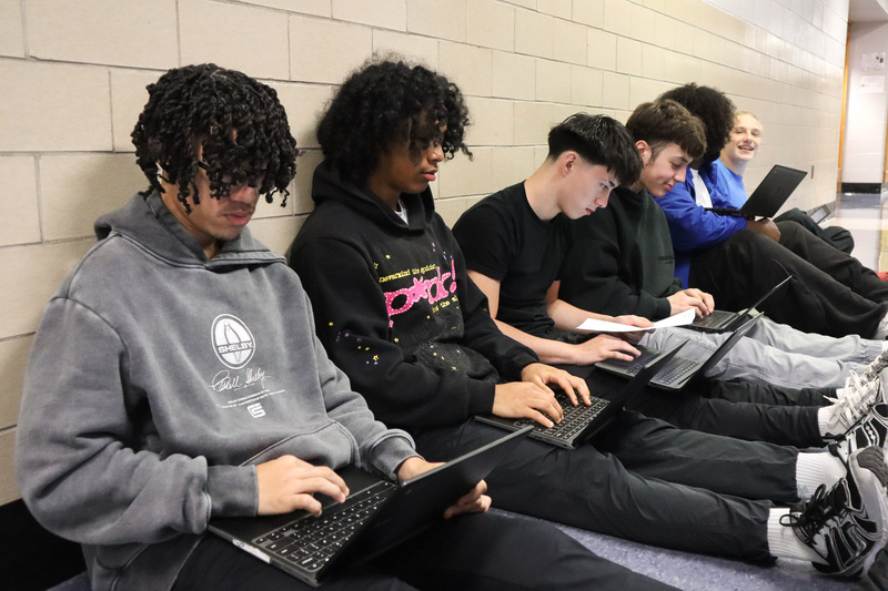 Students work in a group on their laptops