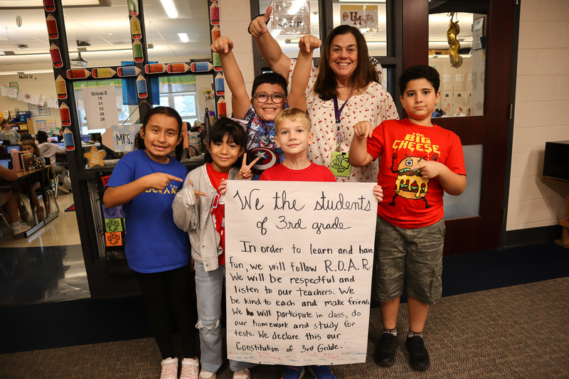 Third graders and their teacher holding their Class Constitution
