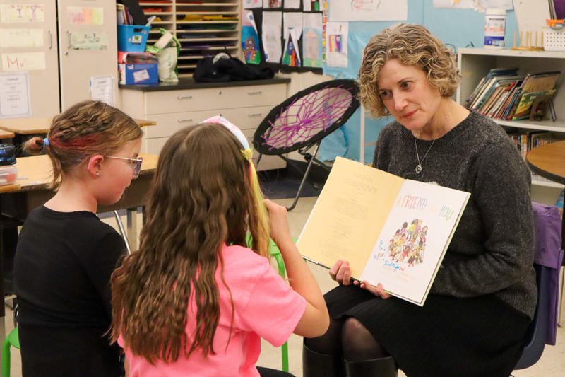 * Dr. Elliott reads to two students