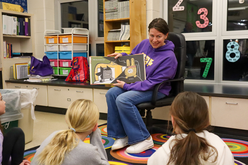 * Mrs. Stainback reads a book to three students