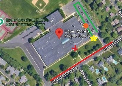 Aerial view of Upper Moreland Middle School and nearby areas, showing the school building, parking, tennis courts, and roads.