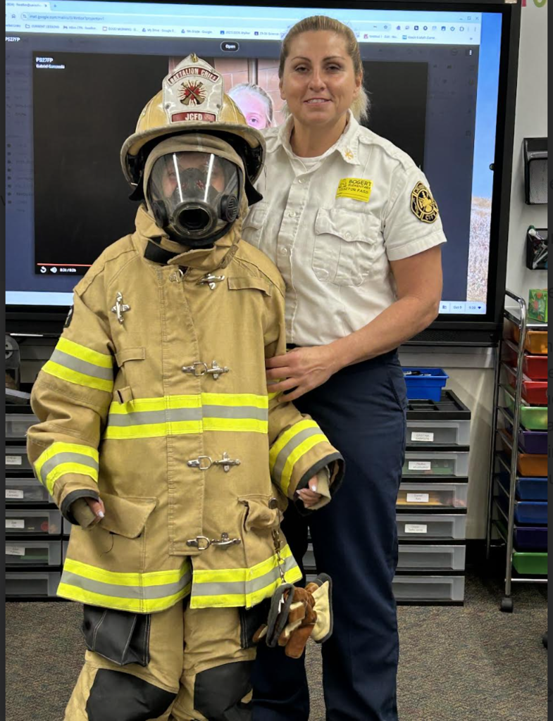 In this photo, Erica is dressed in firefighter gear, which helps keep firefighters safe as they work hard to protect our community.