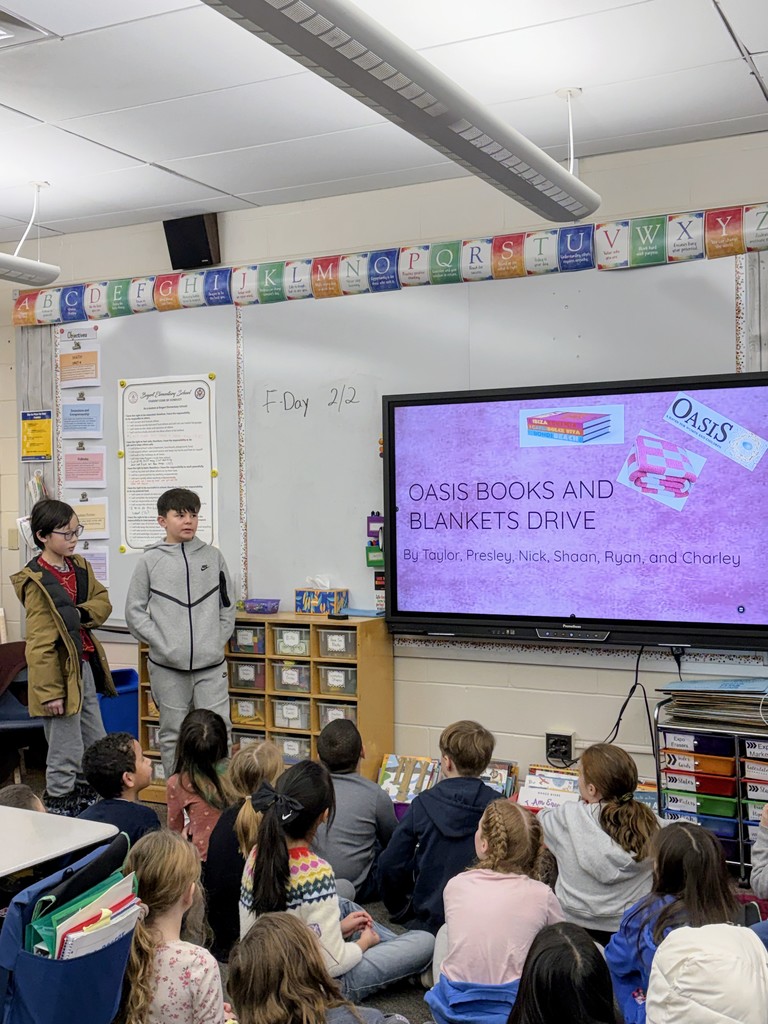 Students presenting about the Oasis Books and Blanket Drive