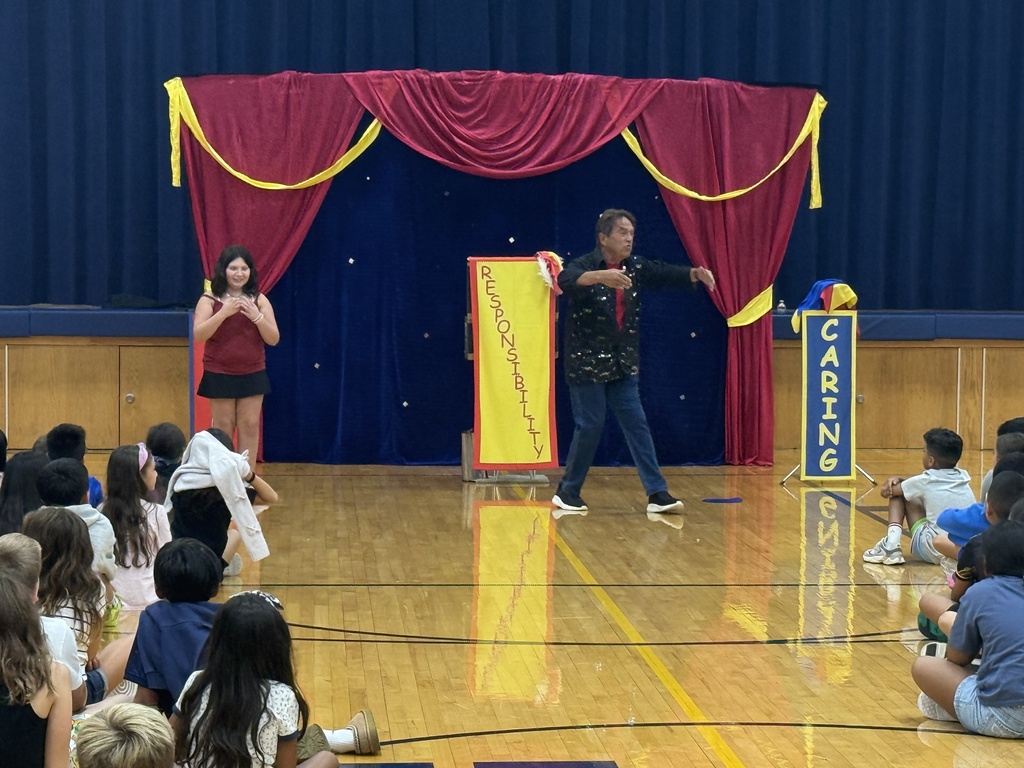 A magician shows off a magic trick with help from a student. 