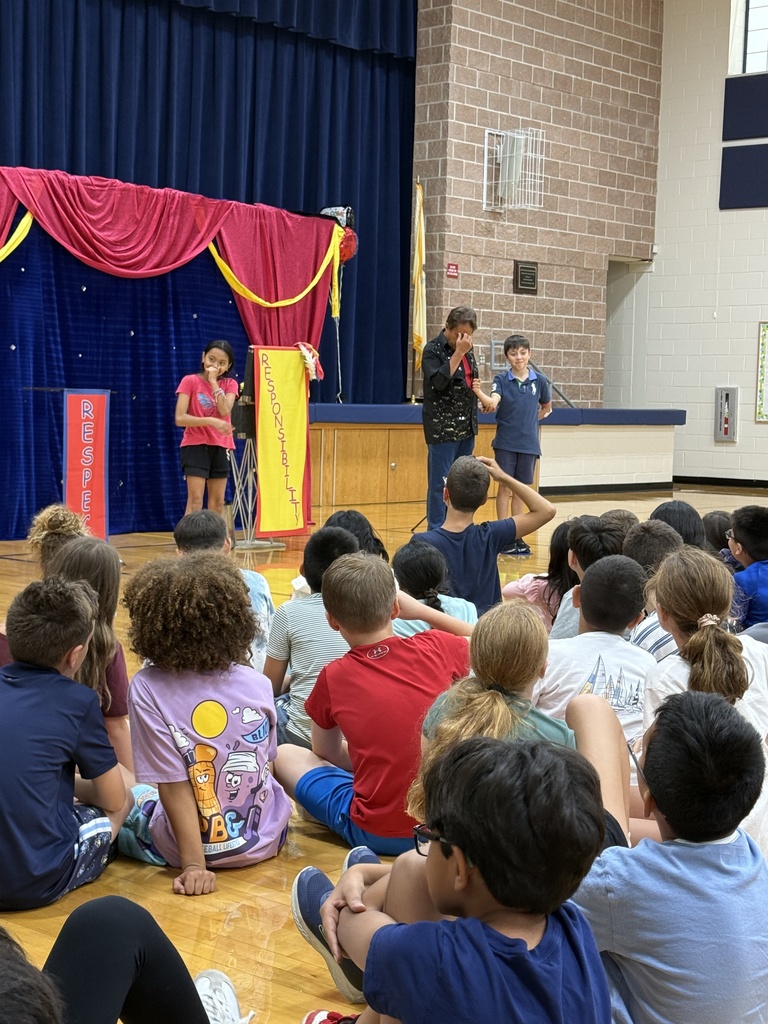 A magician shows off a magic trick with help from 2 students. 