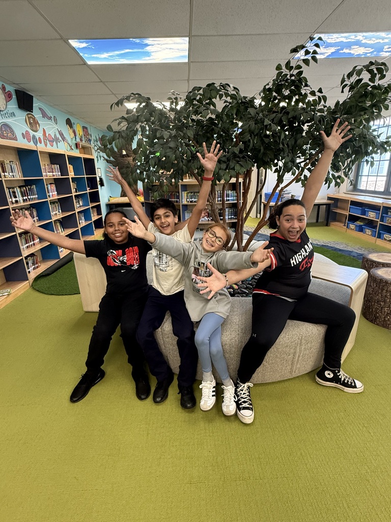 4 fifth grade students show excitement in a library.