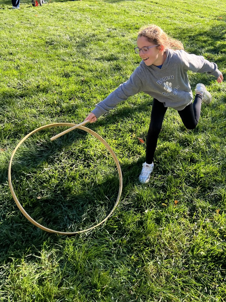 Student plays stick with a hoop game.