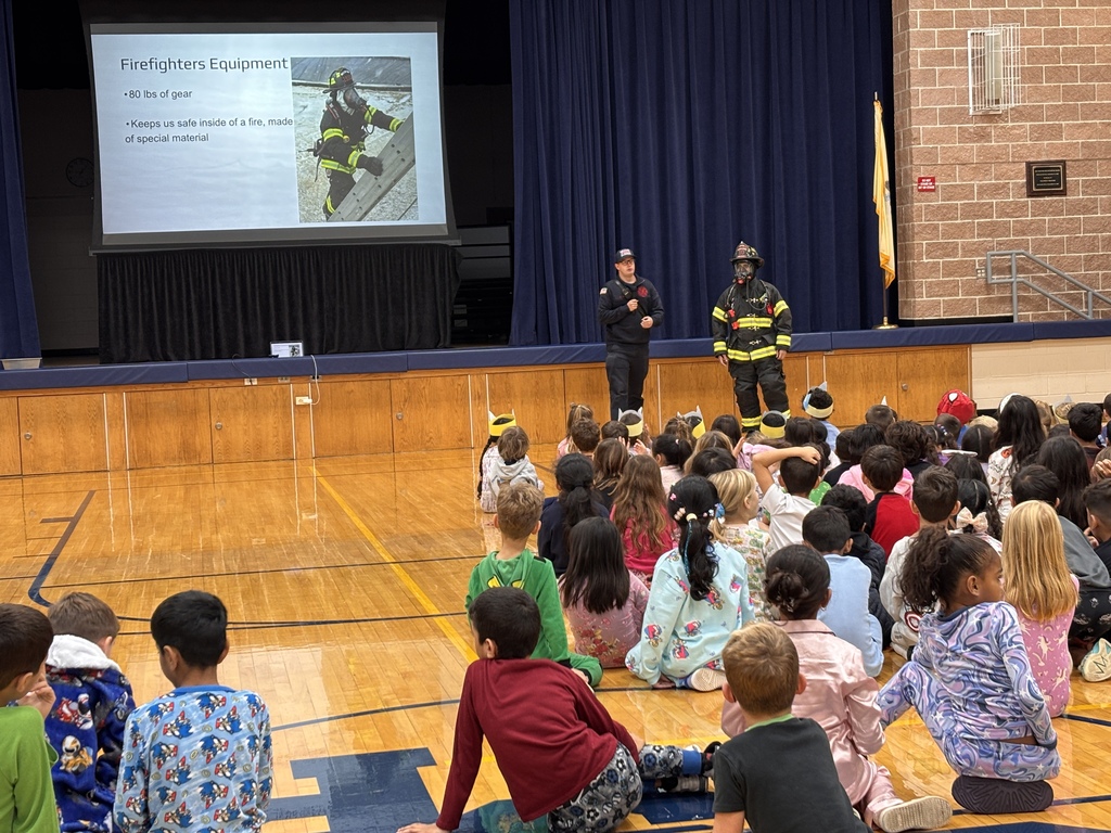 Students listen to firefighters at a firefighter assembly.