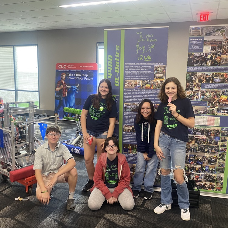 robotics team in front of banners