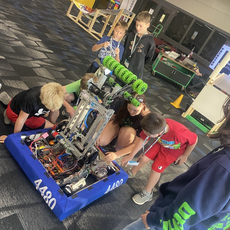 students looking at a robot