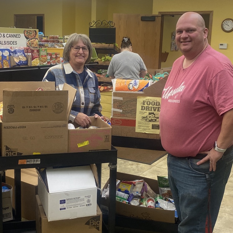 two posing with food donations