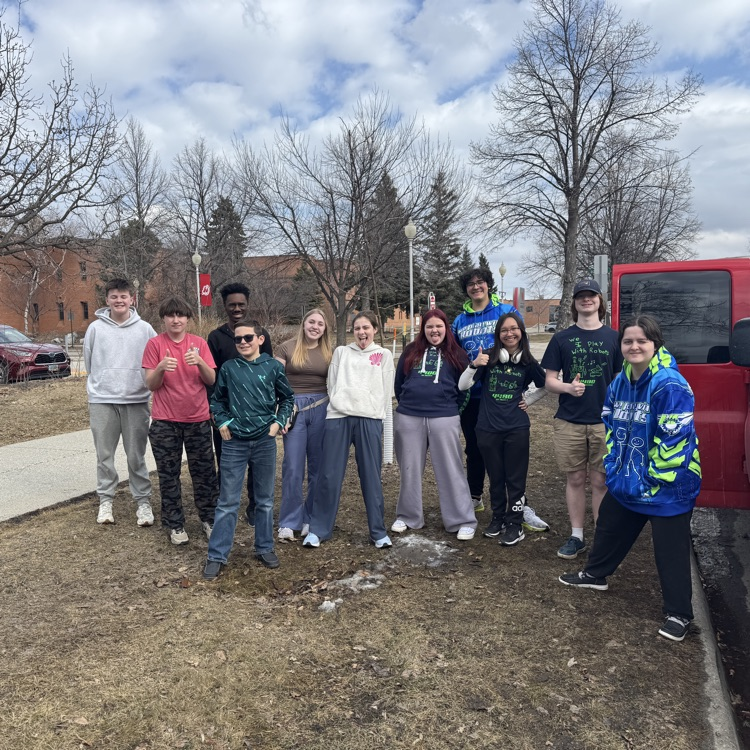 team standing in front of school