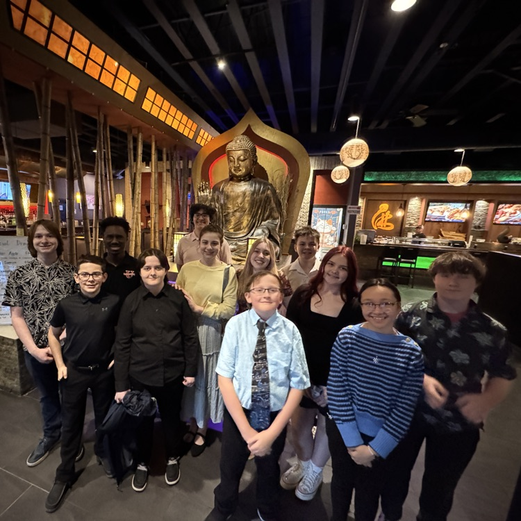 dressed up students in front of statue