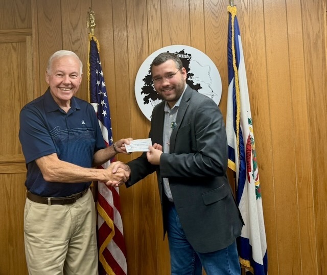 Don Nestor gives a check to Director of Student Nutrition and Wellness