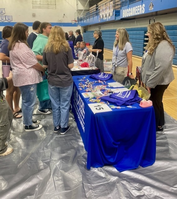Picture of the career fair day at Buckhannon-Upshur High School. Includes the UCS table and students actively looking at job oppotunities.