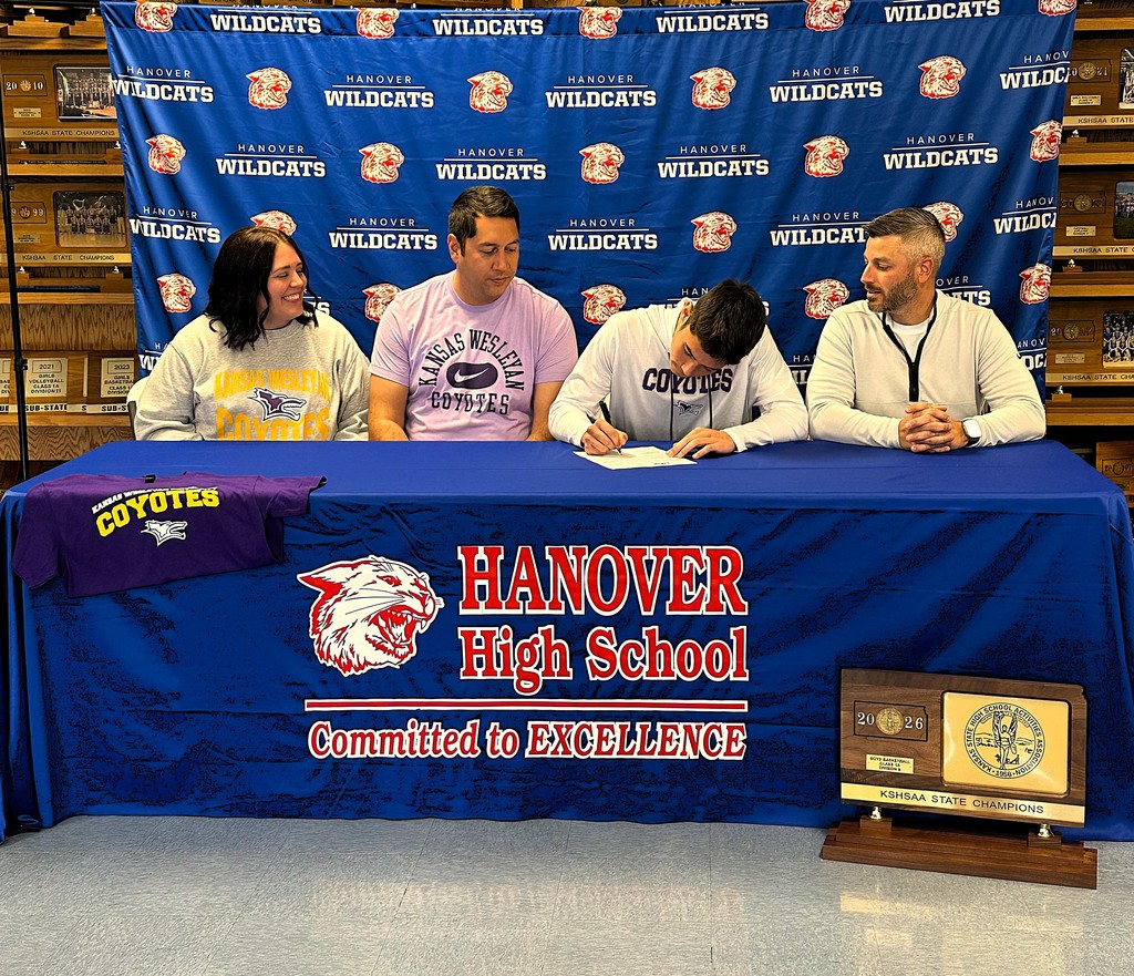 Braylon signs with parents, Chris and Renee, and Coach Cory Jensen looking on.